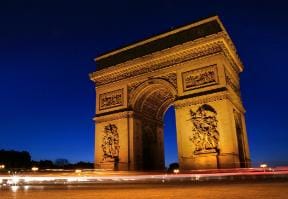 Photo de l'Arc de Triomphe éclairé de nuit. 