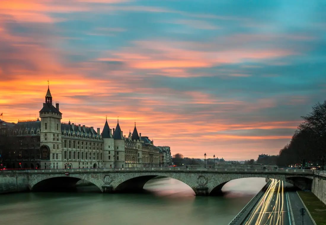 Photo de Paris le matin avec vue sur le Louvre, un pont et la Seine